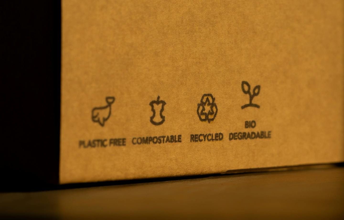 Plastic free, compostable, recycled, biodegradable labels shown on a cardboard box